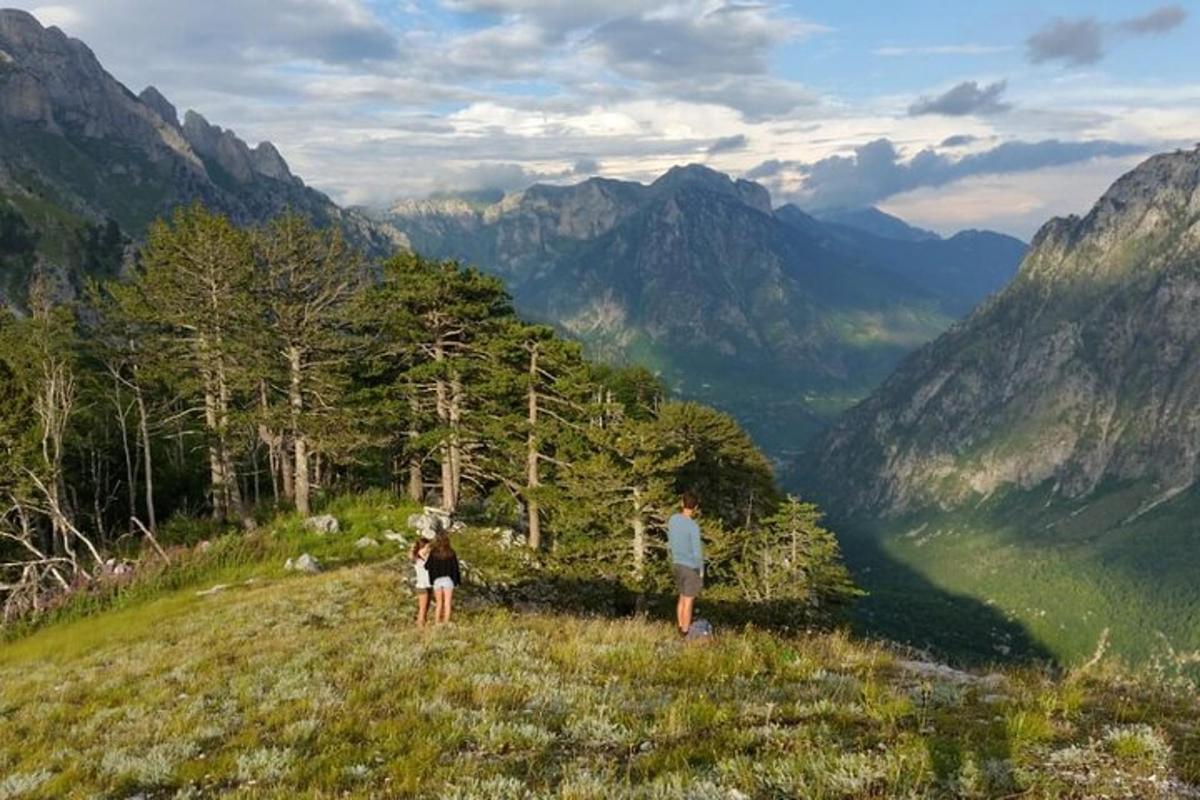 due persone in piedi su una collina che guardano una valle