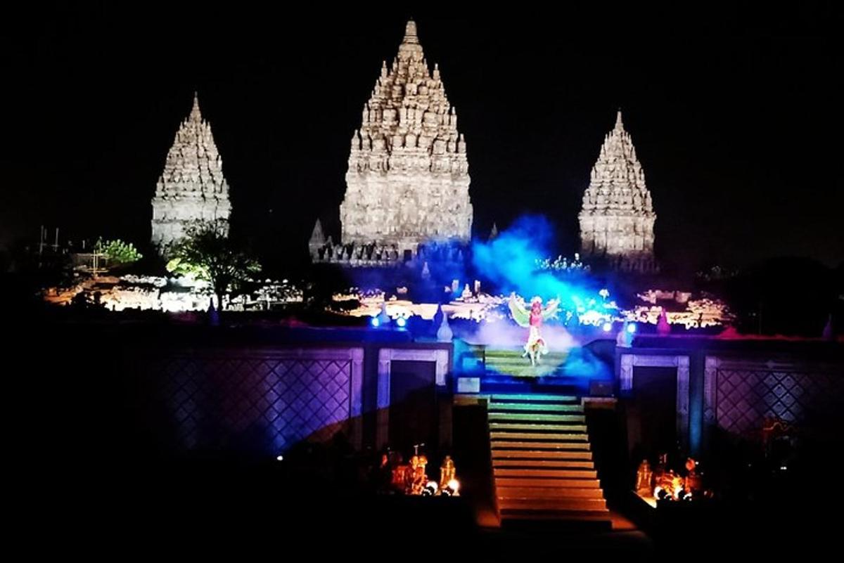 a lit up temple at night with a woman on the stairs