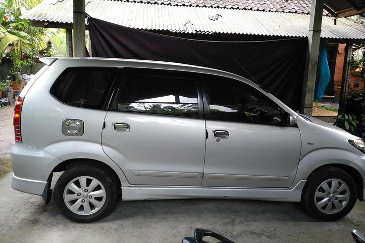sebuah mobil putih terparkir di depan tenda