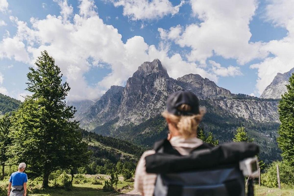 Una mujer parada frente a una vista de montañas.