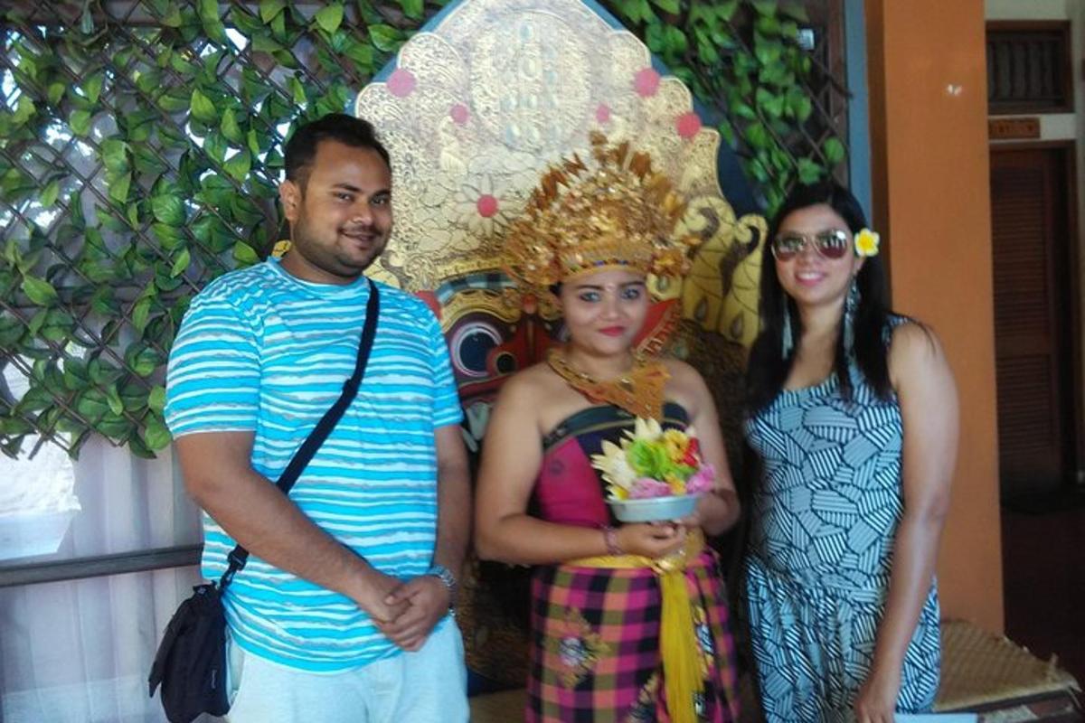 seorang pria dan dua wanita berdiri di depan sebuah patung