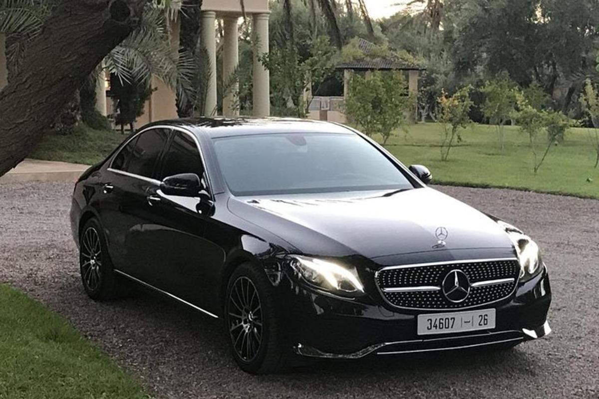 um carro preto estacionado em frente a uma casa