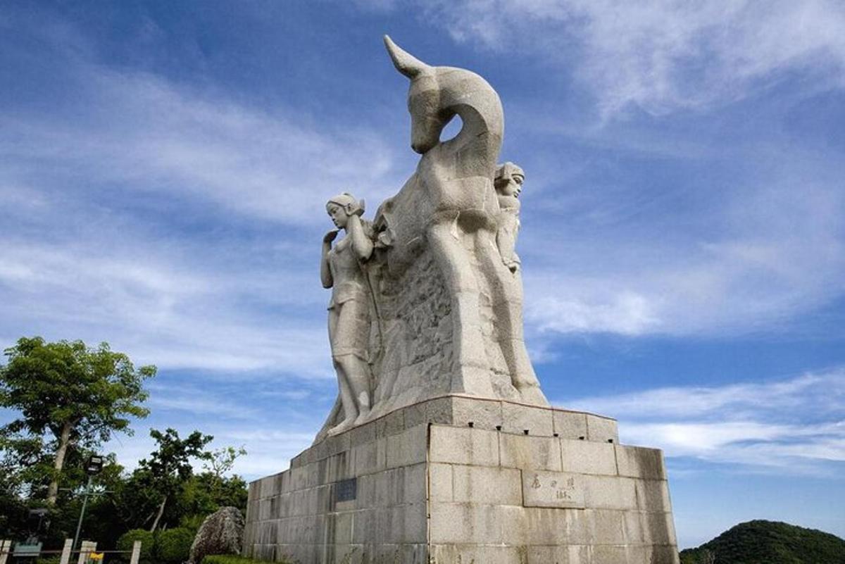 a statue in a park with a blue sky