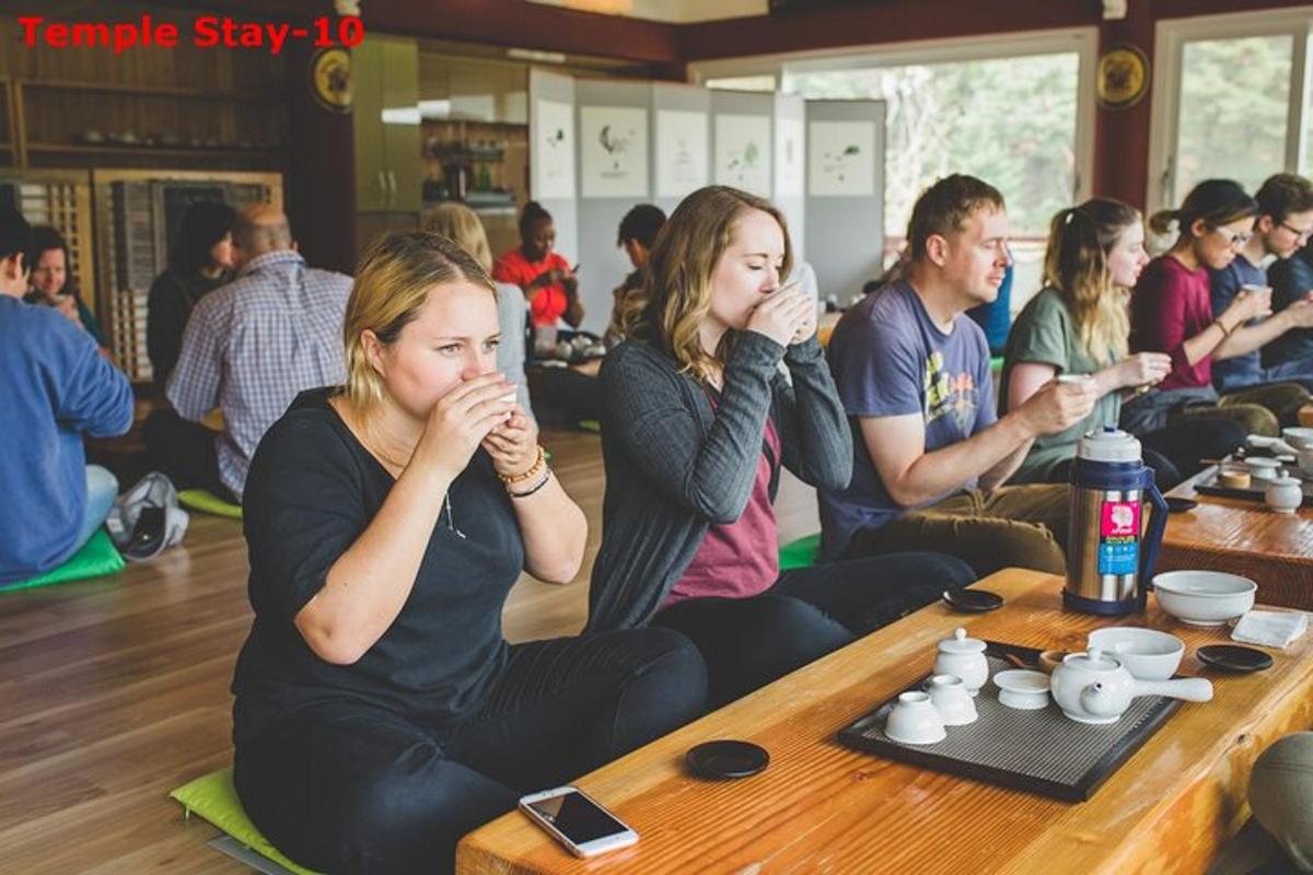a group of people sitting at a table drinking tea