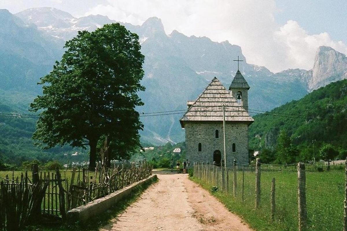 pieni rakennus pellolla, jossa on aita
