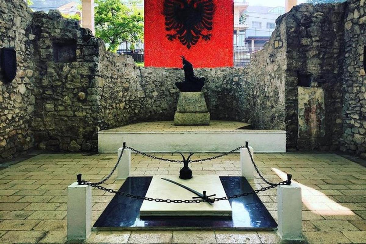 ένα άγαλμα σε μια αυλή με κόκκινο τοίχο