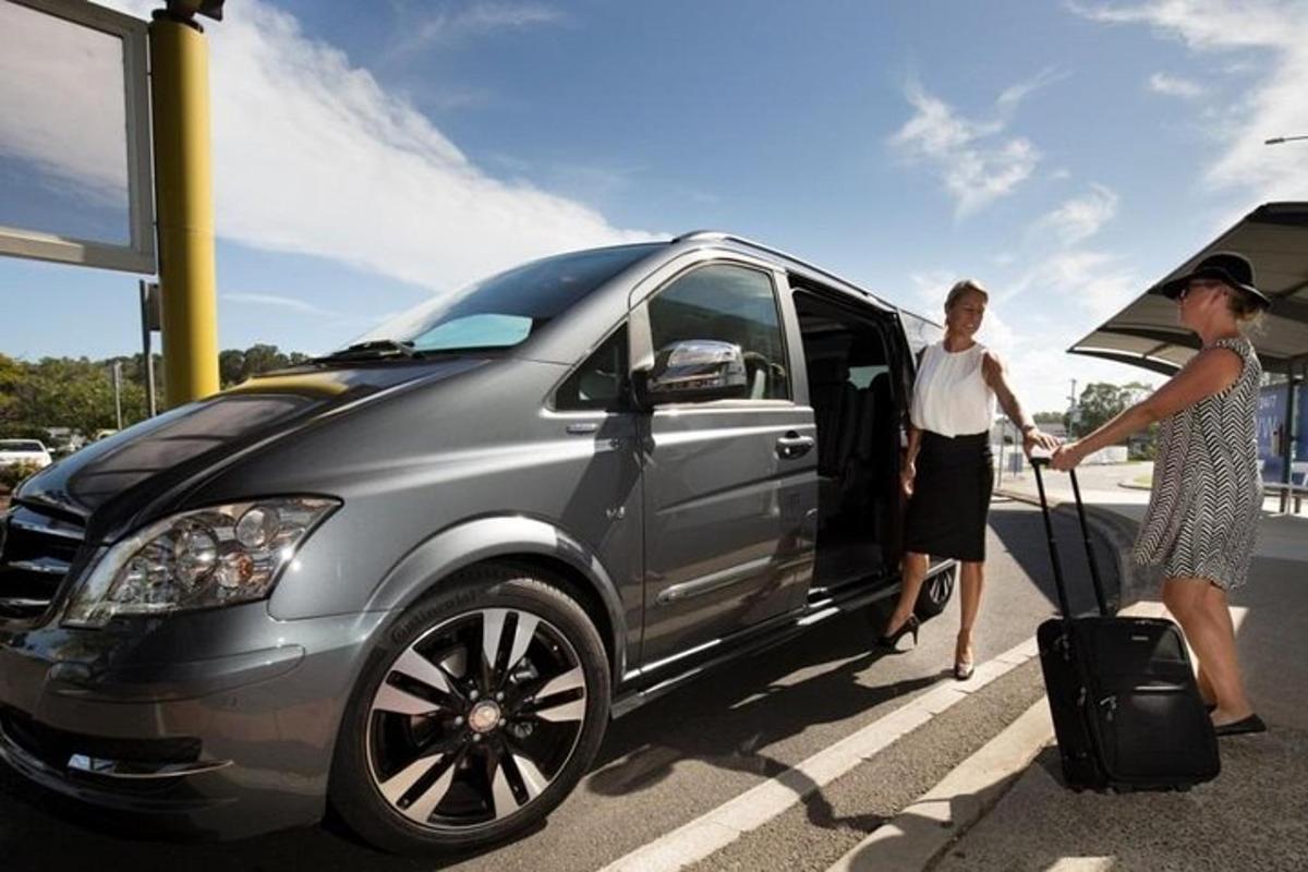 um homem e uma mulher entrando em um carro em um posto de gasolina