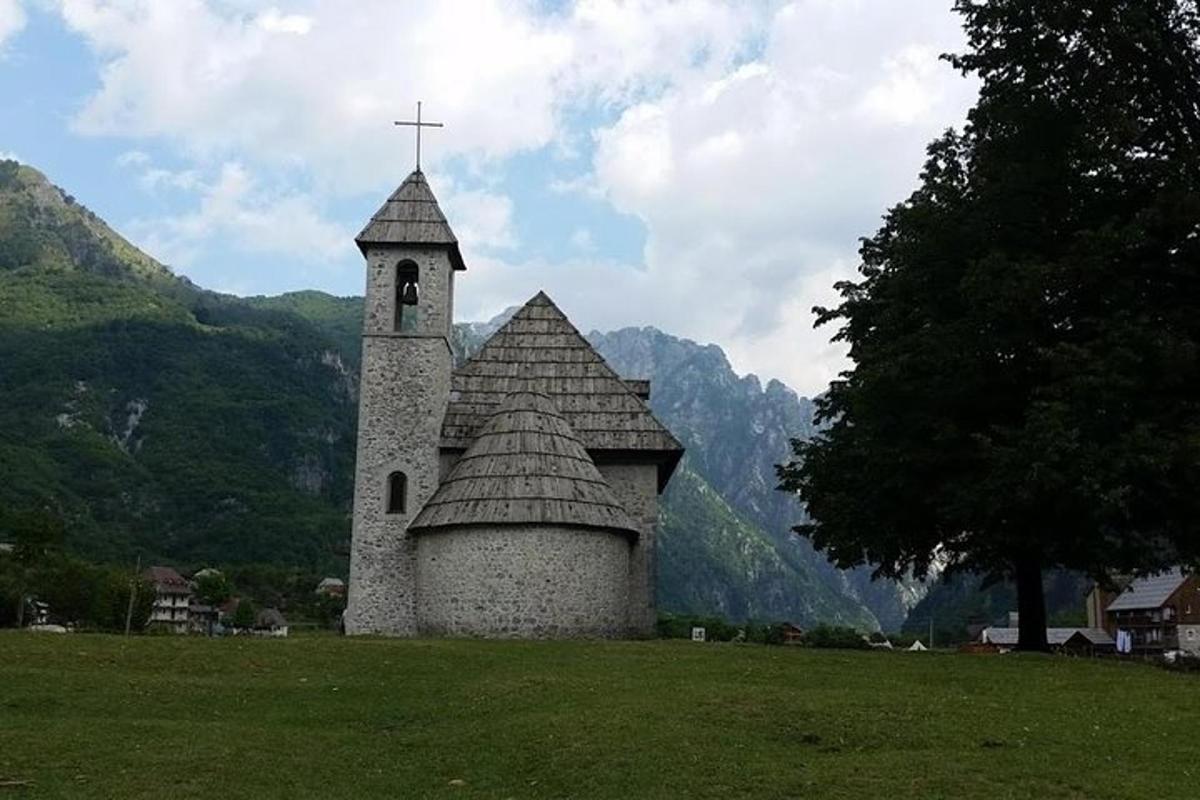 una chiesa con una croce in cima a un campo
