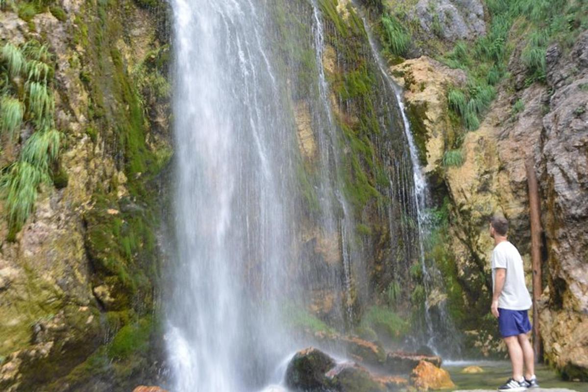 un uomo in piedi davanti a una cascata