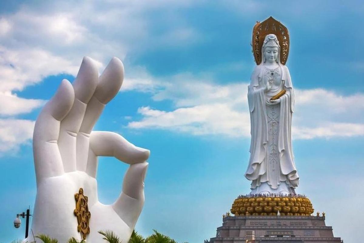 a hand reaching up to a statue in front of a statue