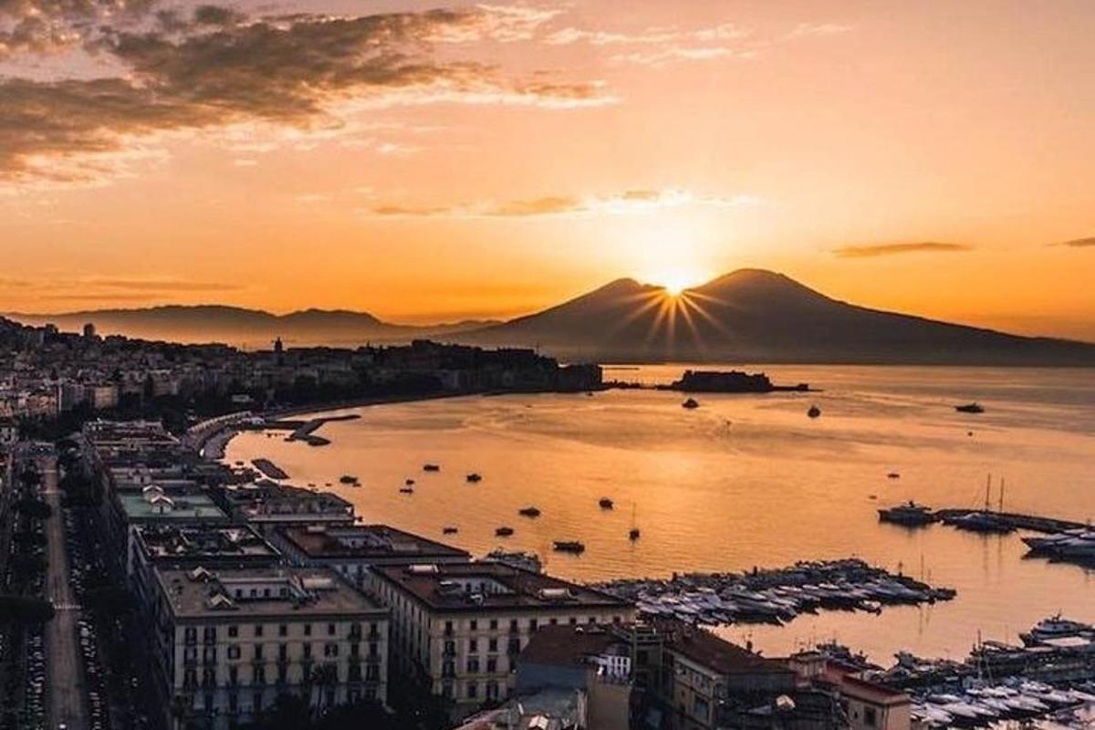 Una puesta de sol sobre una ciudad con un puerto con barcos.