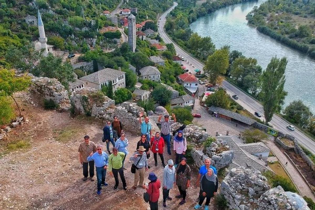 skupina lidí jdoucích po kopci poblíž řeky