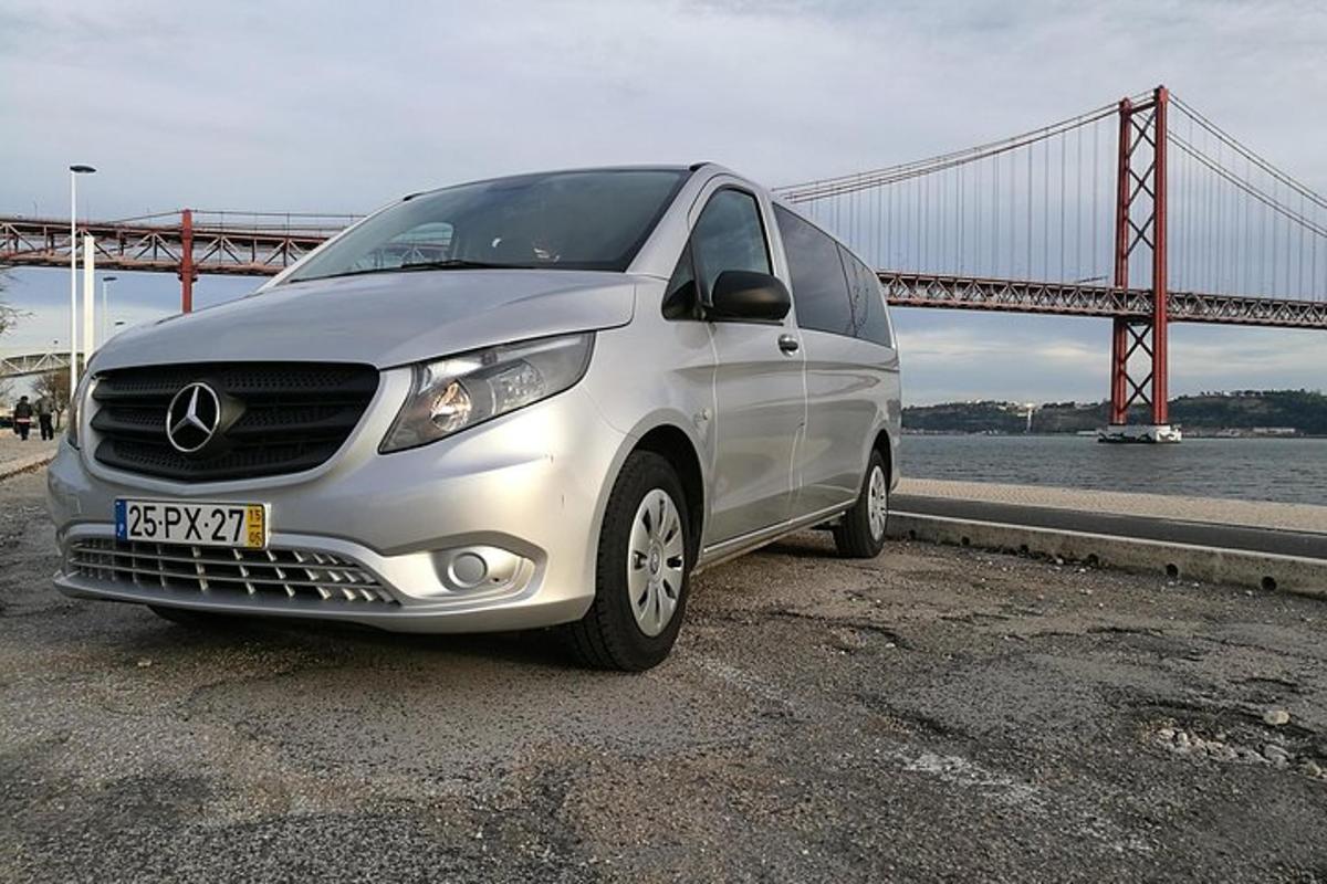 stříbrné auto zaparkované před mostem