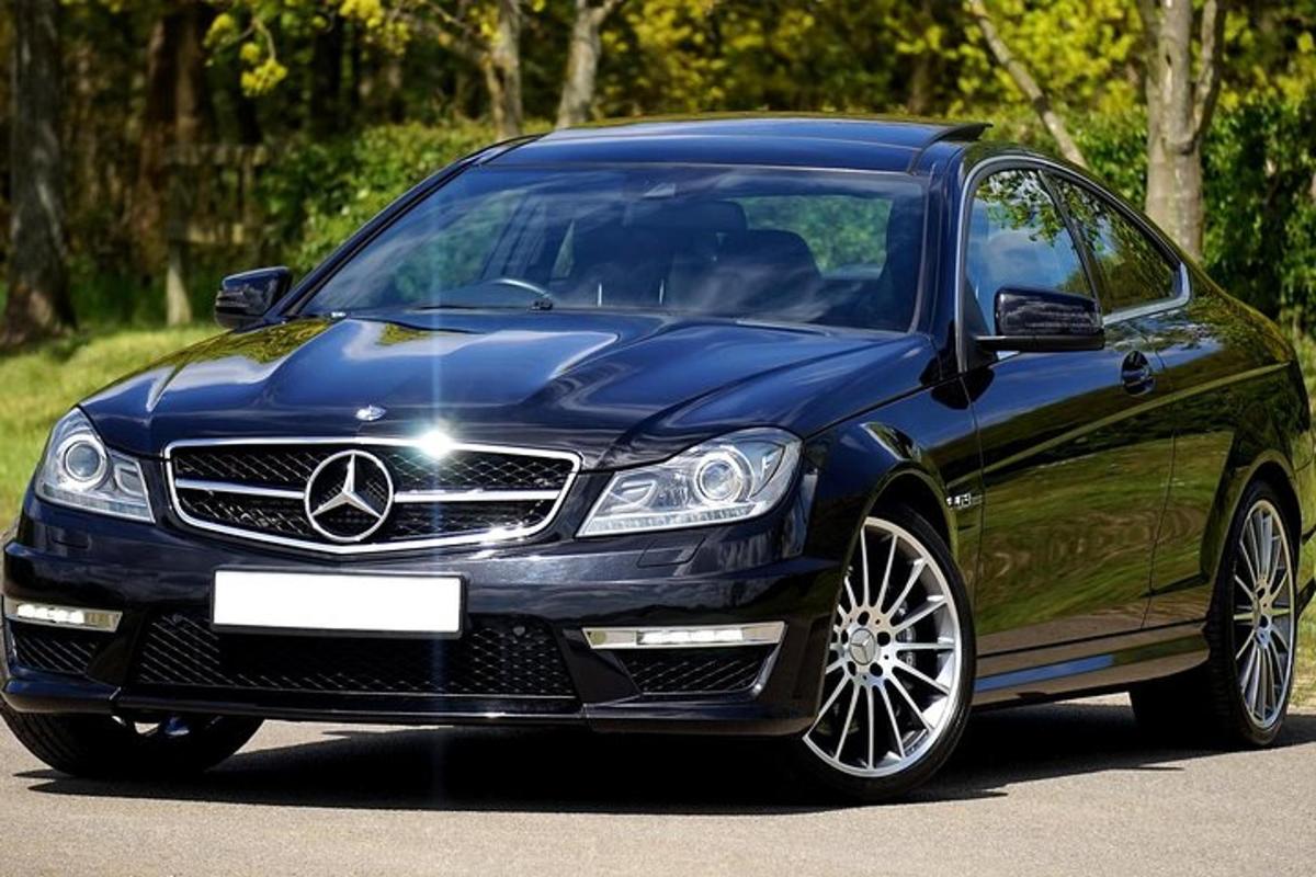 un cotxe Mercedes Benz blau aparcat en una carretera