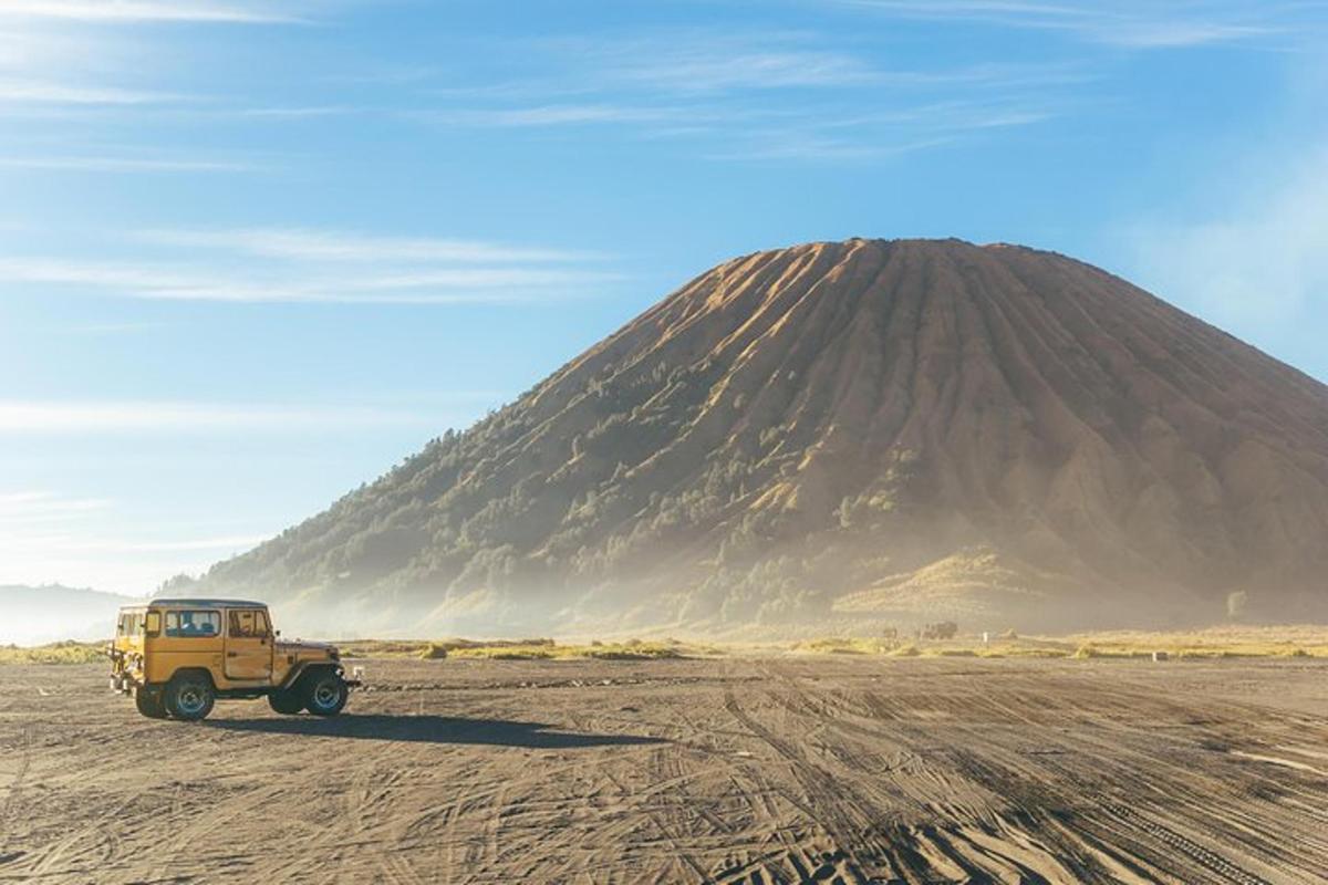 ein gelber Jeep, der vor einem Berg geparkt ist