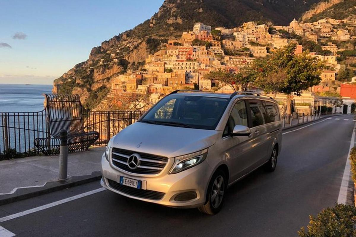un furgone argentato parcheggiato su una strada vicino all'oceano