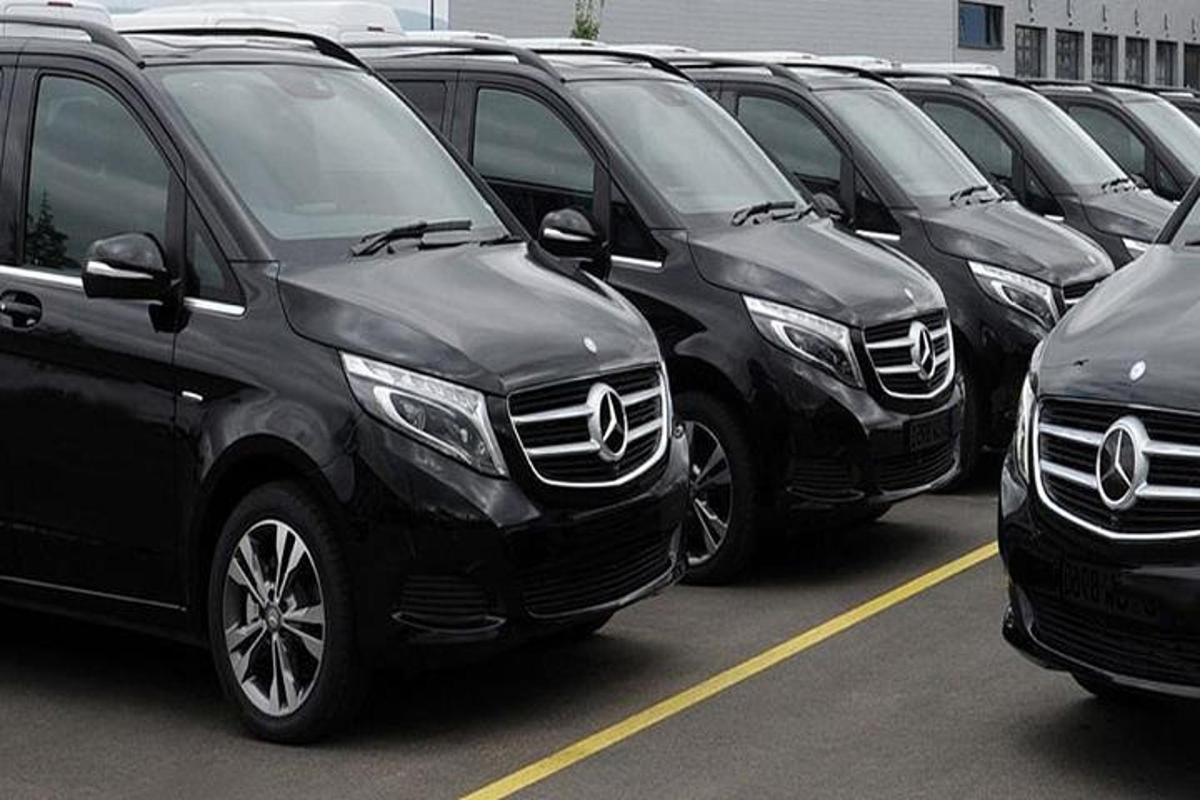 a row of black suvs parked in a parking lot