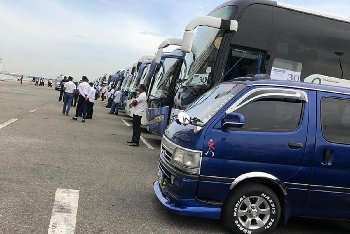 a group of people standing in front of buses