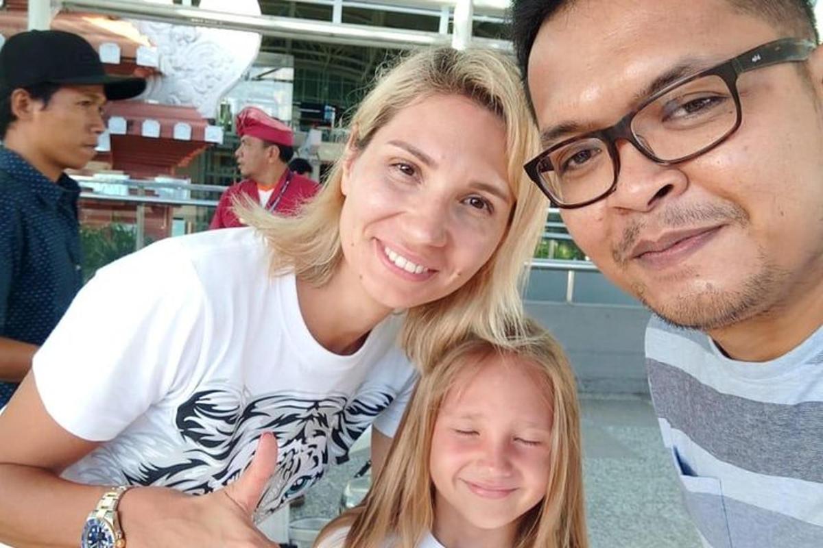 un uomo e una donna posano per una foto con una bambina
