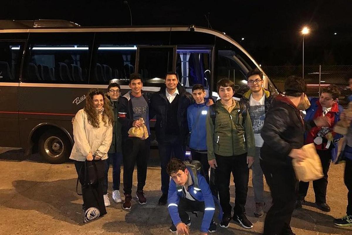 joukko ihmisiä seisoo bussin edessä