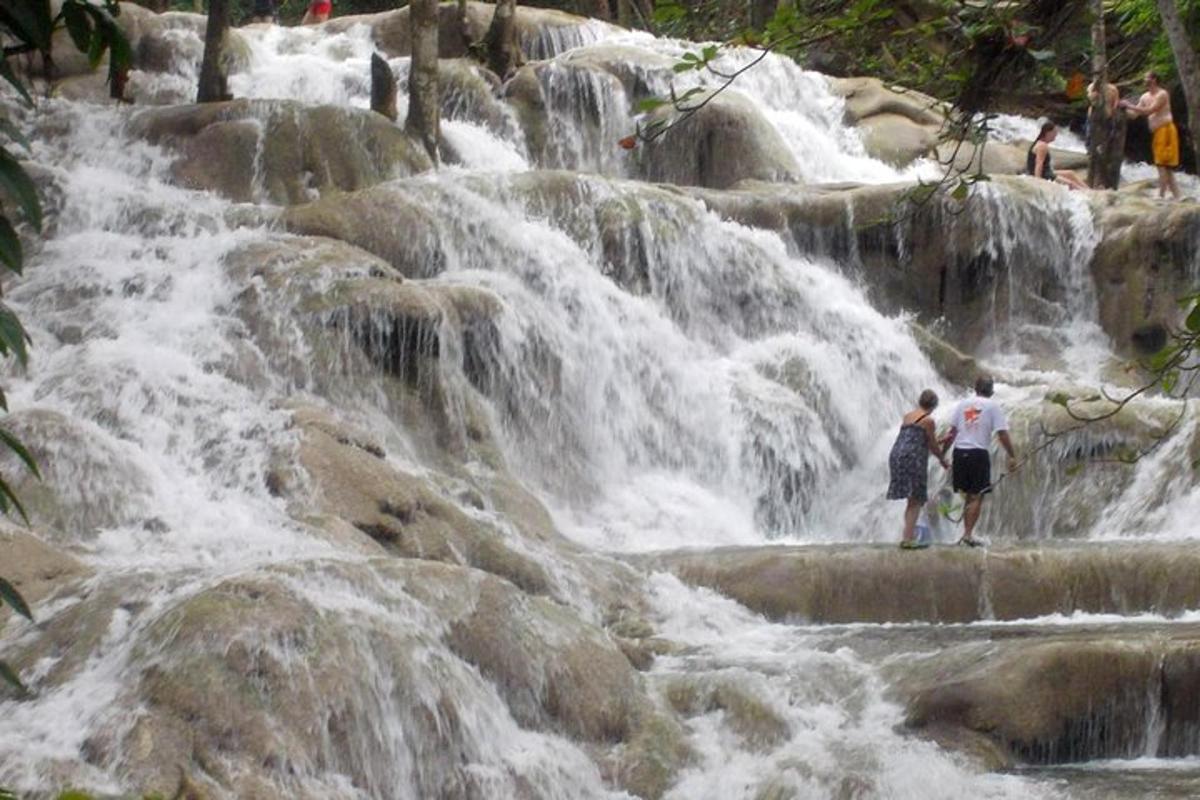 two people standing in front of a waterfall