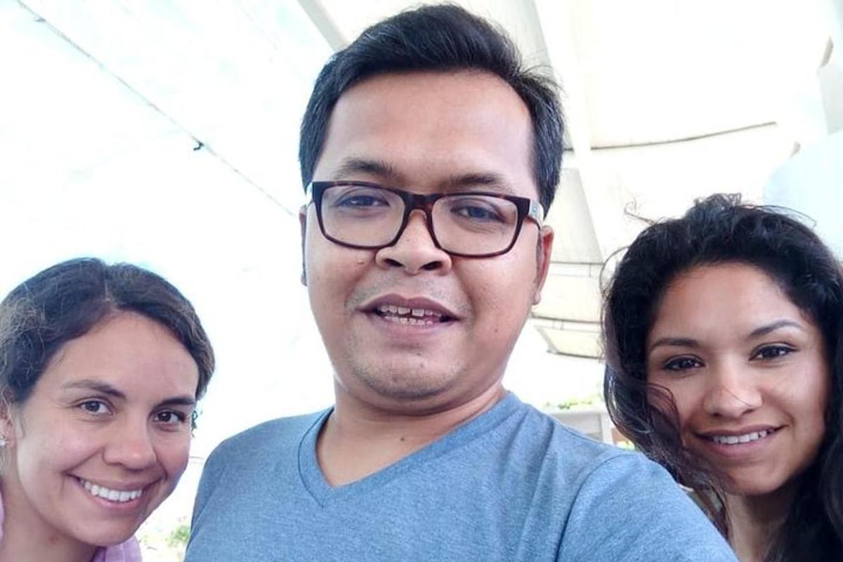 Un hombre y dos mujeres posando para una fotografía