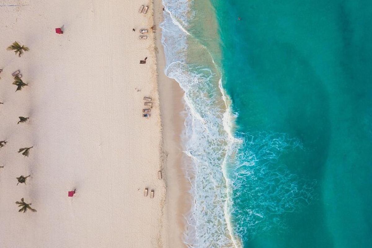una vista cenital d'una platja amb gent i l'oceà