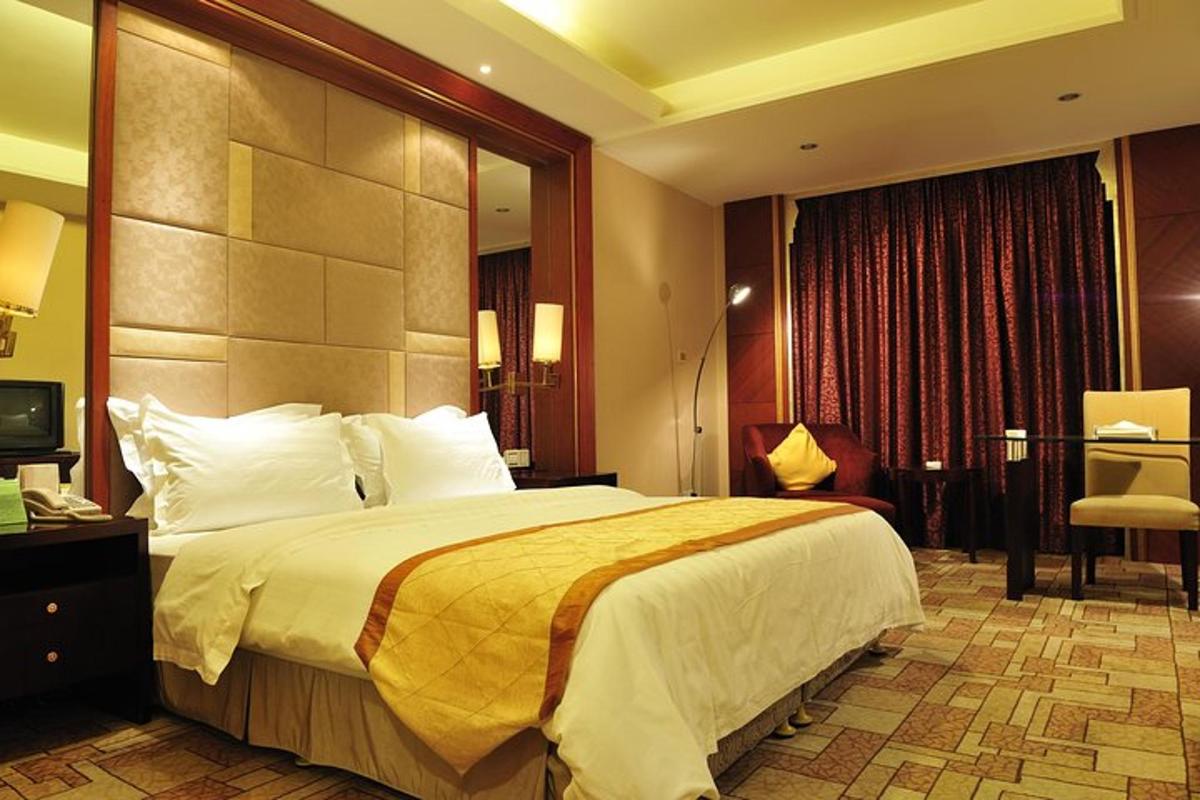 una camera d'albergo con un letto grande e una sedia