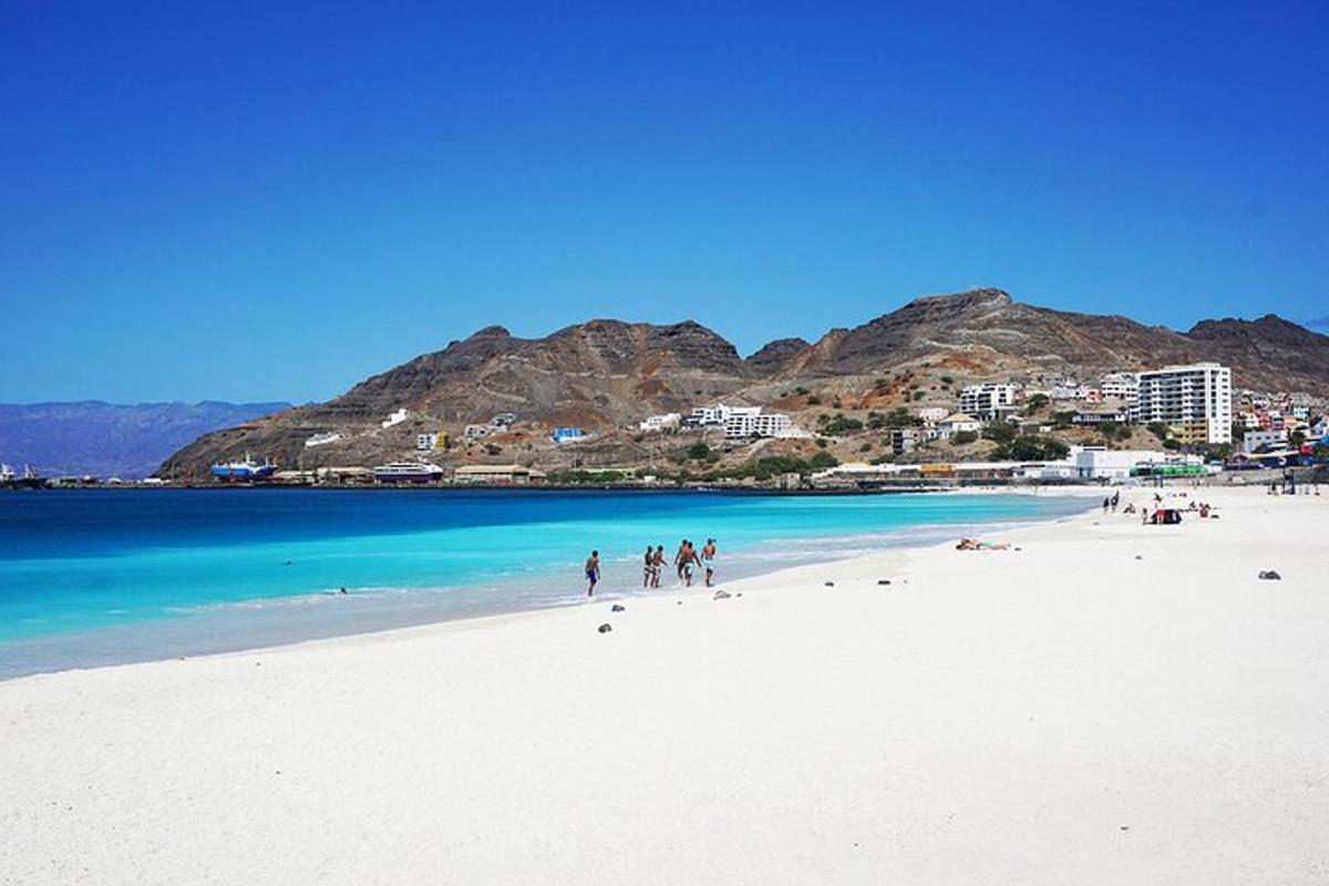 a group of people walking on a white beach