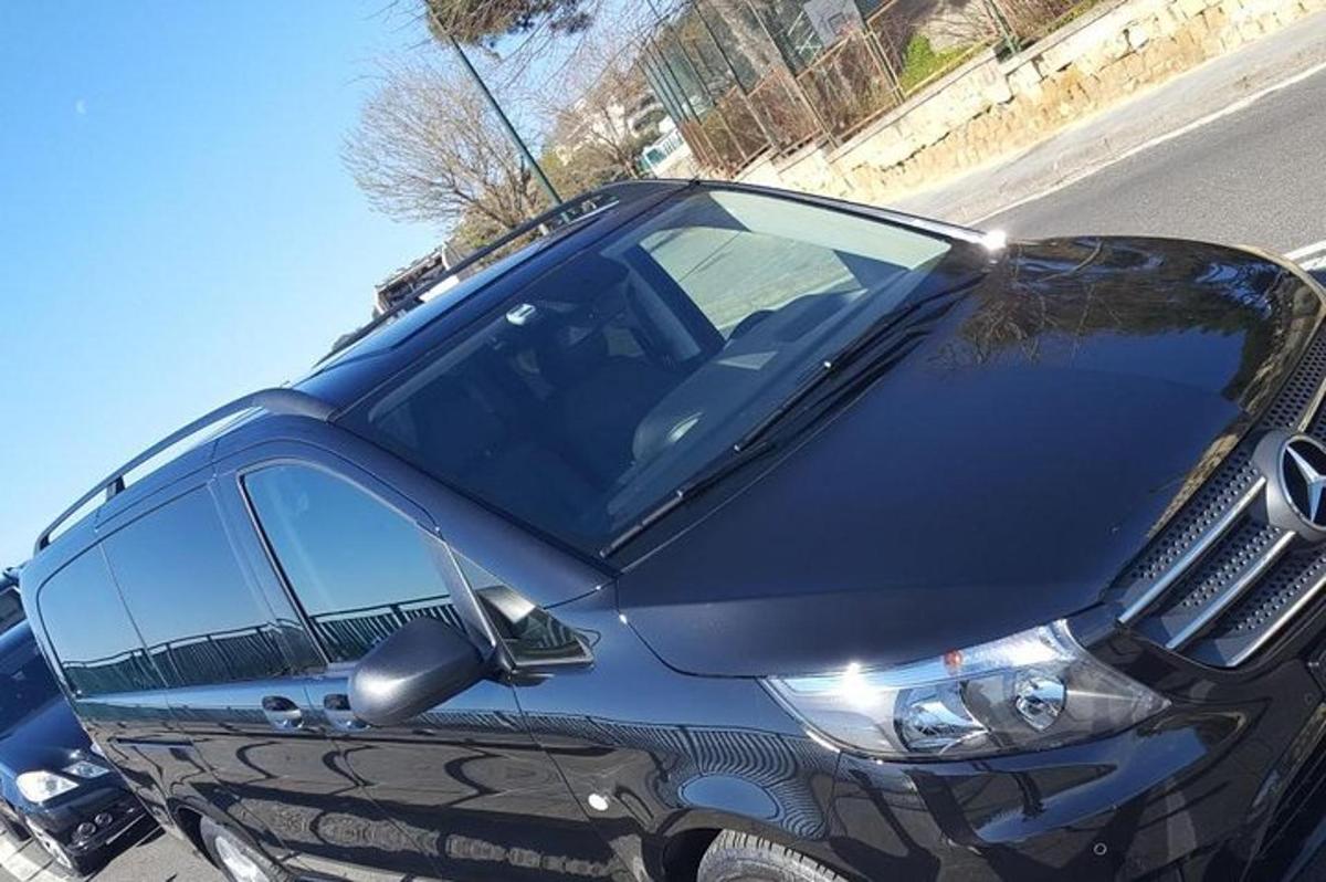 um carro preto estacionado na beira de uma rua
