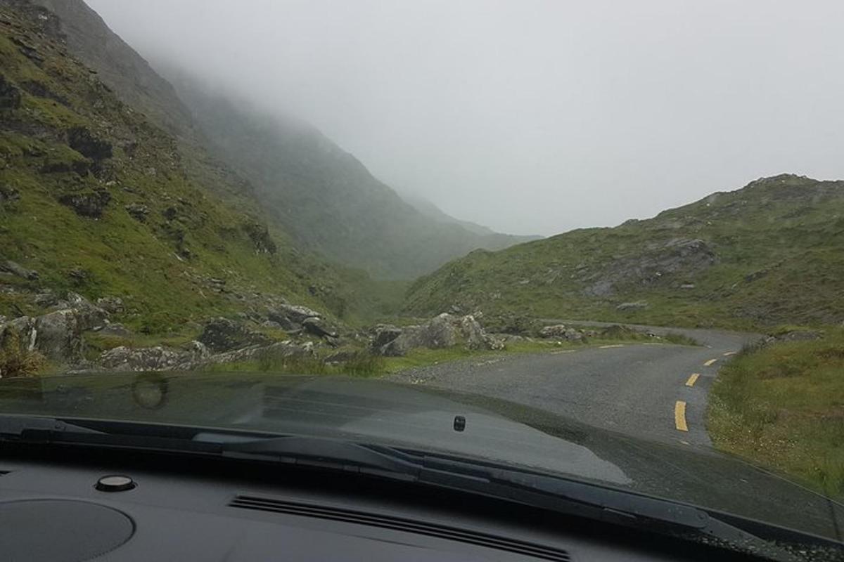 a car driving down a road in the mountains
