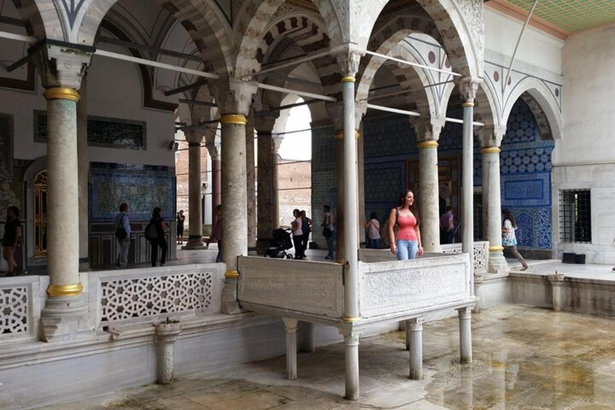 Una mujer parada en un gran edificio con columnas.