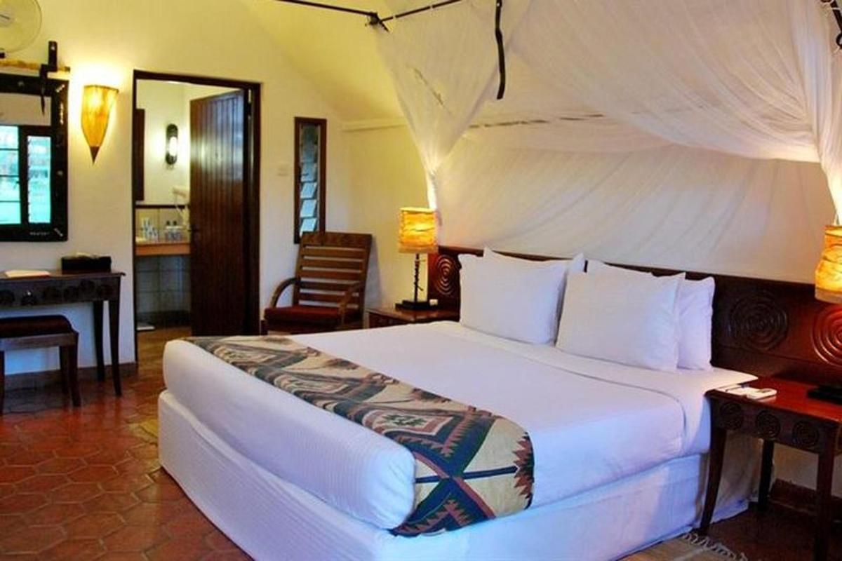a bedroom with a large white bed in a room