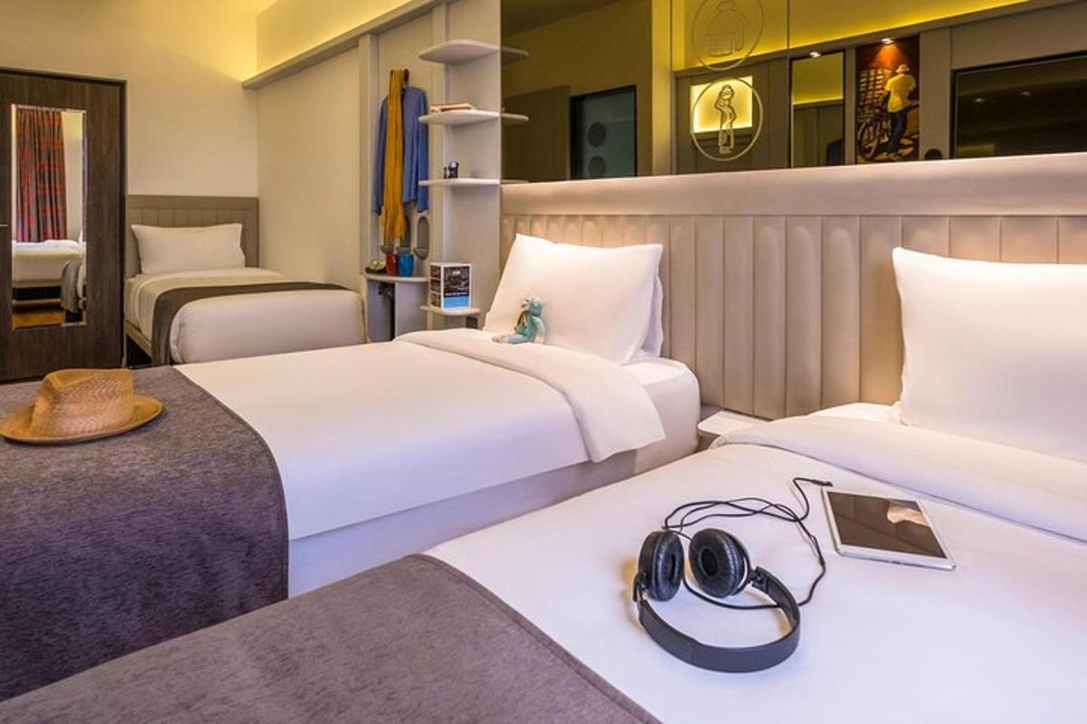 a hotel room with two beds with hats on them