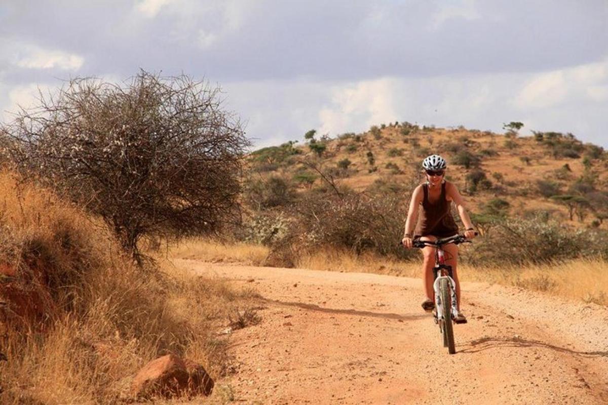a man riding a bike on a dirt road