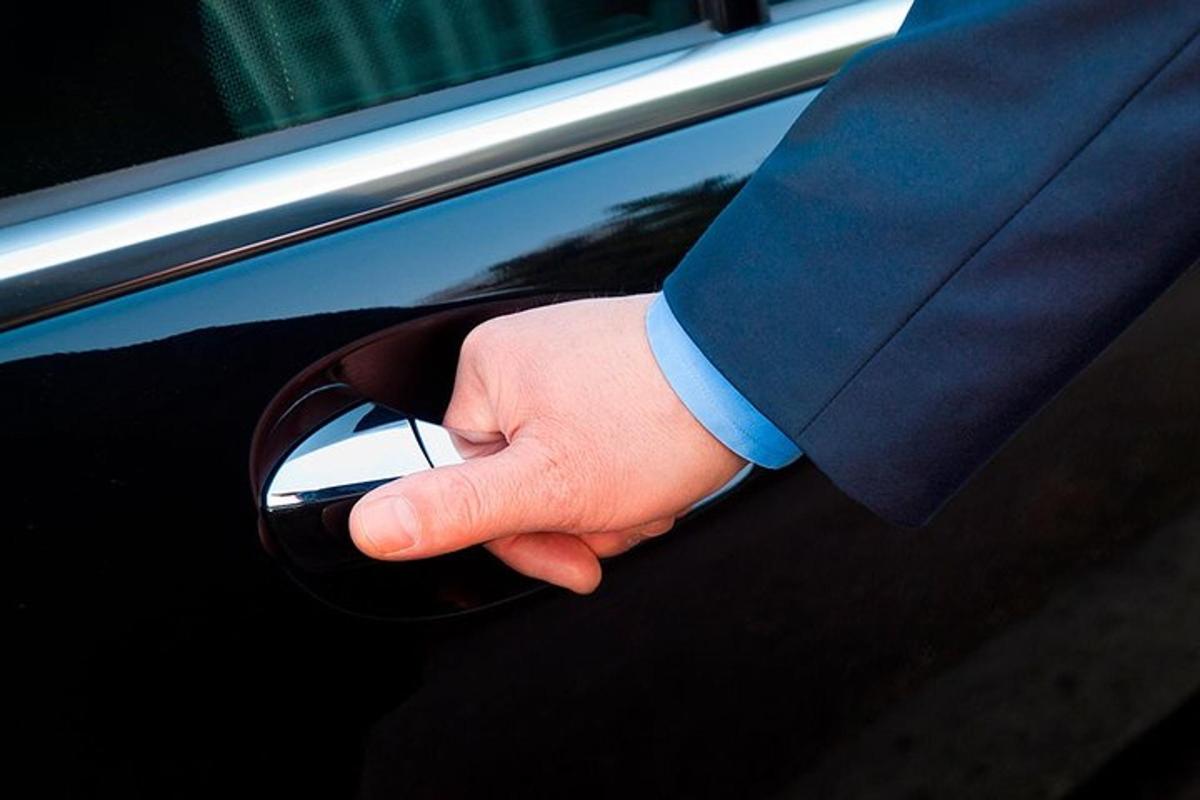 Un hombre con traje está abriendo la puerta de un coche.