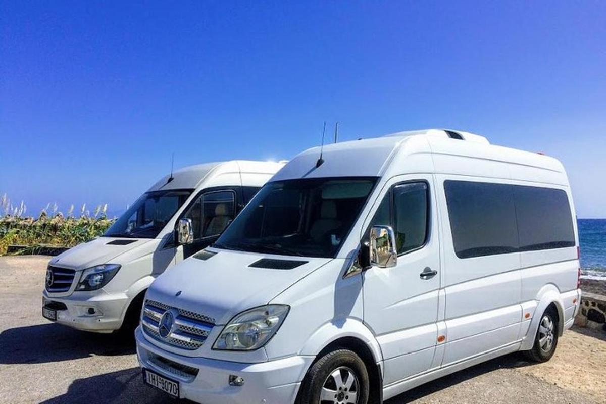 to hvite varebiler parkert ved havet