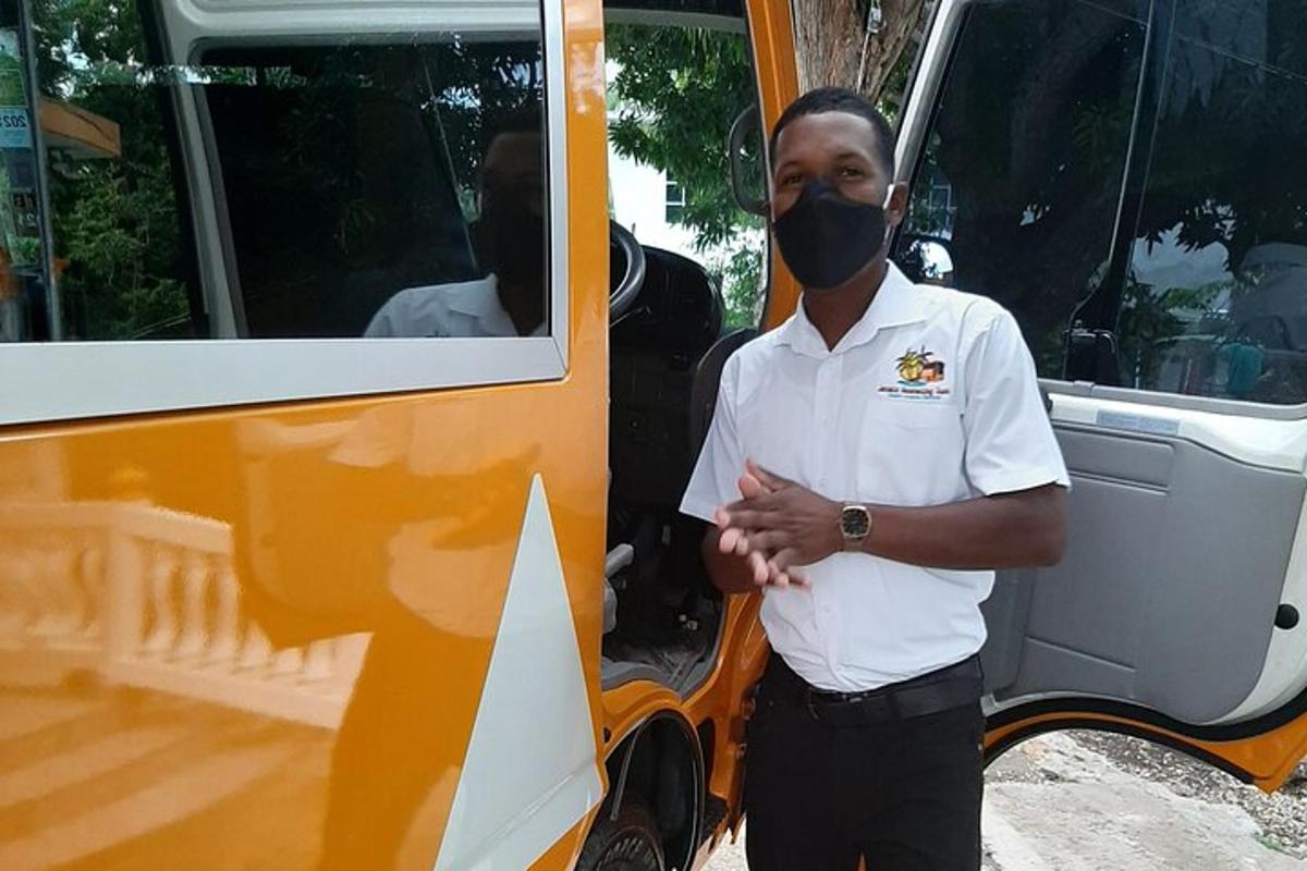 Ein Mann mit einer Maske steht neben einem Bus