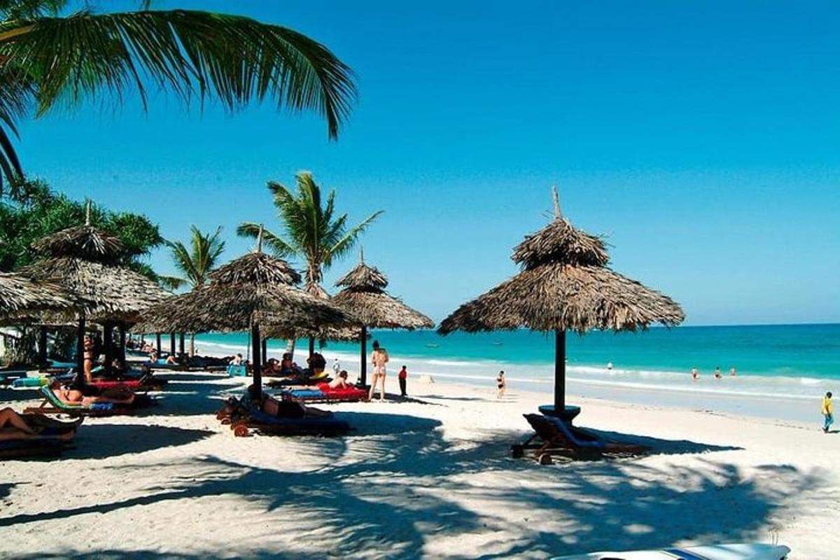 pantai dengan payung jerami dan orang di pantai