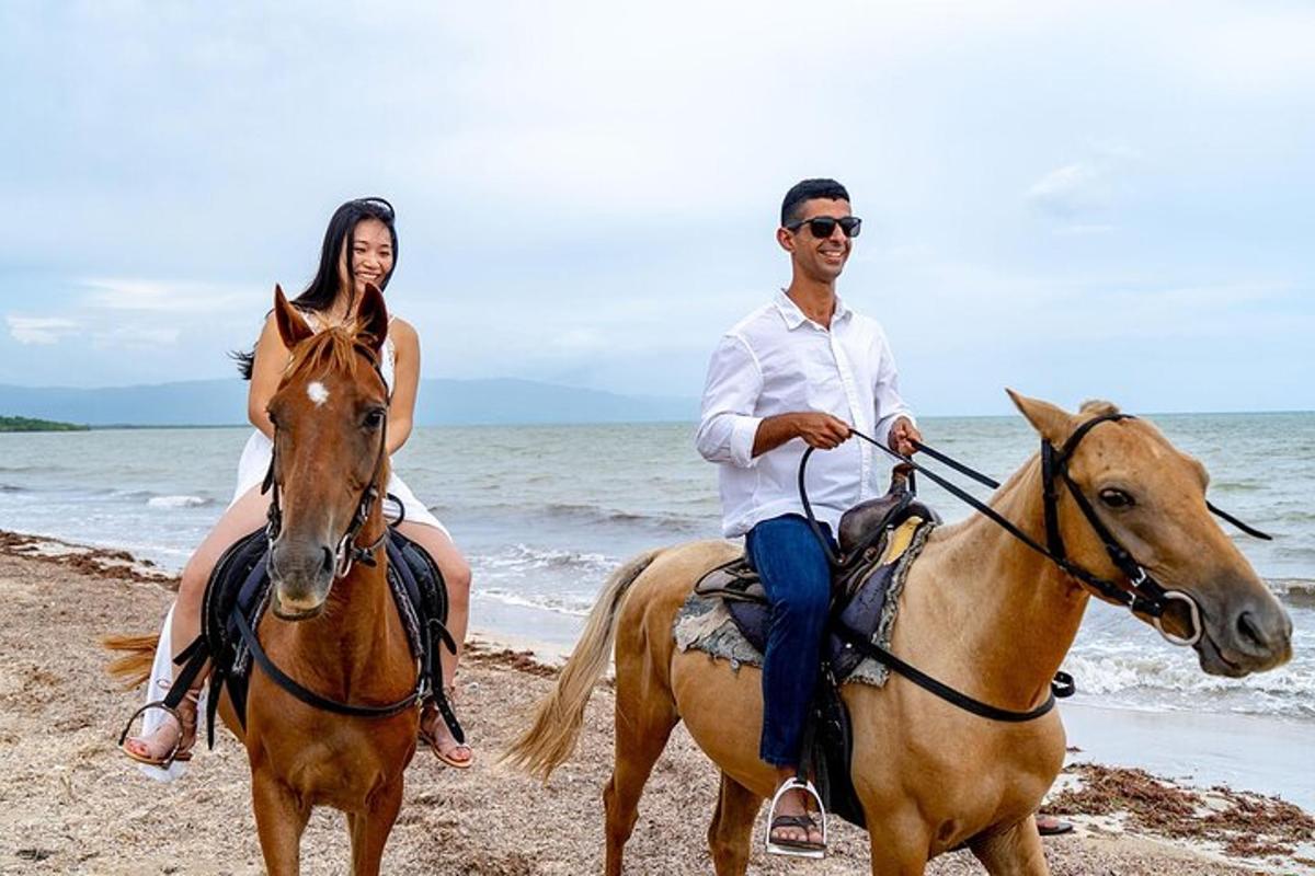 seorang lelaki dan seorang wanita menunggang kuda di pantai