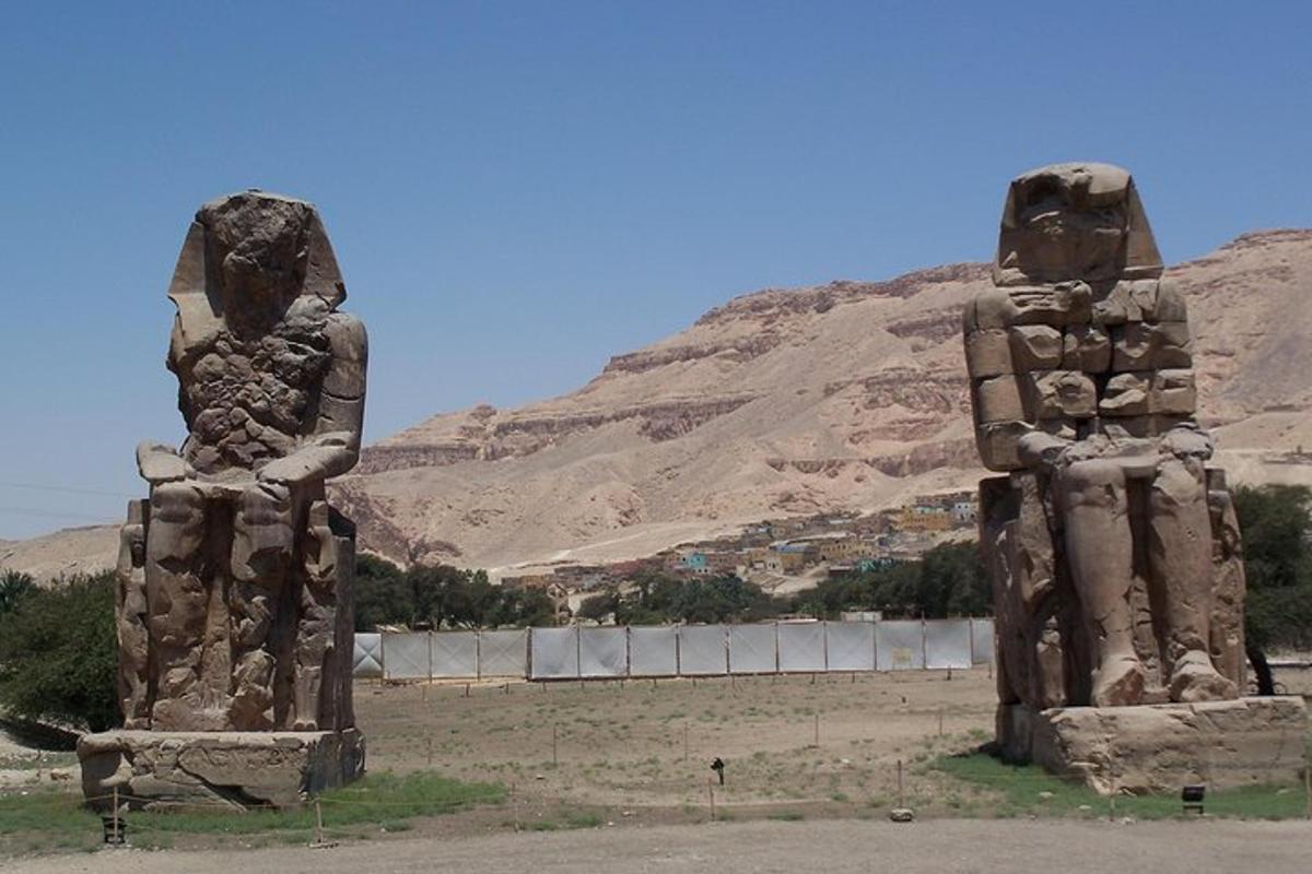 due statue di due persone in piedi accanto a una montagna