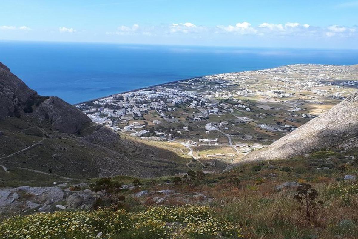 a view of a city from a mountain with the ocean