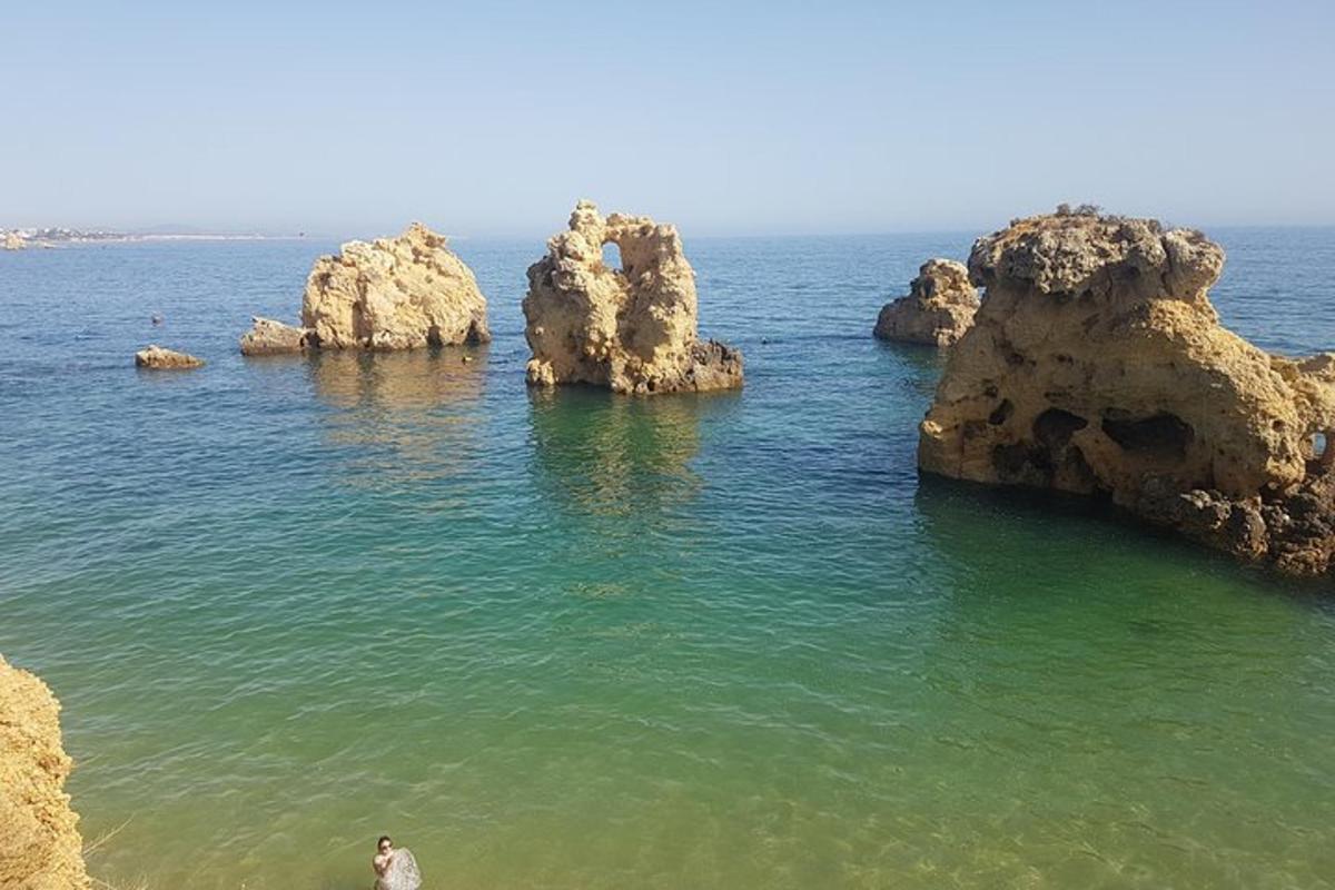 un uomo in piedi nell'acqua vicino ad alcune rocce