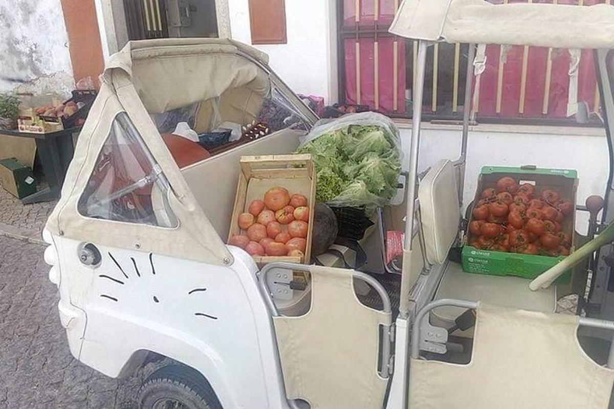egy fehér autó, hátul gyümölcsökkel és zöldségekkel