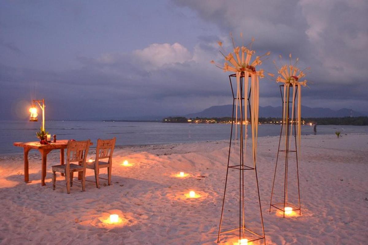 un tavolo e delle sedie su una spiaggia con luci