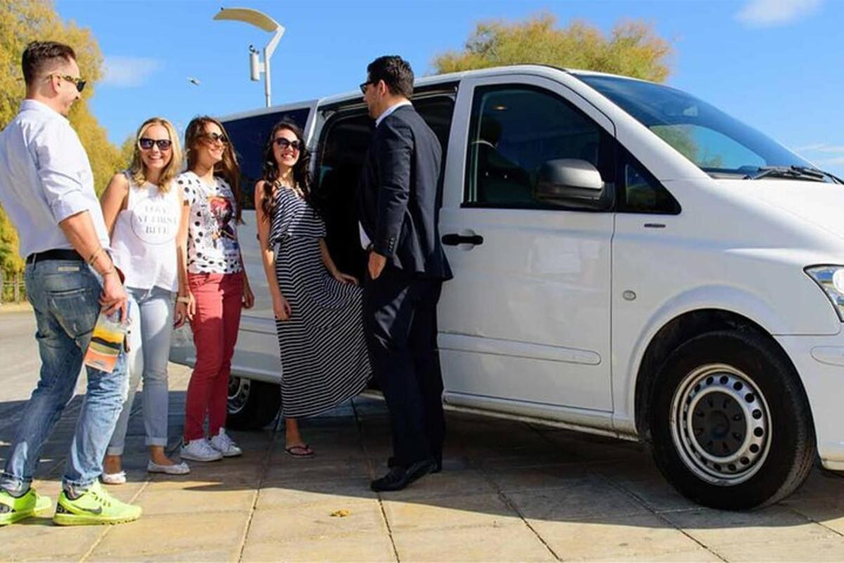 Un grupo de personas de pie junto a una camioneta blanca.