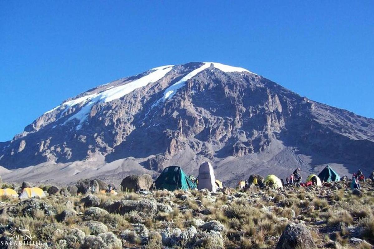 a group of tents and a snow covered mountain