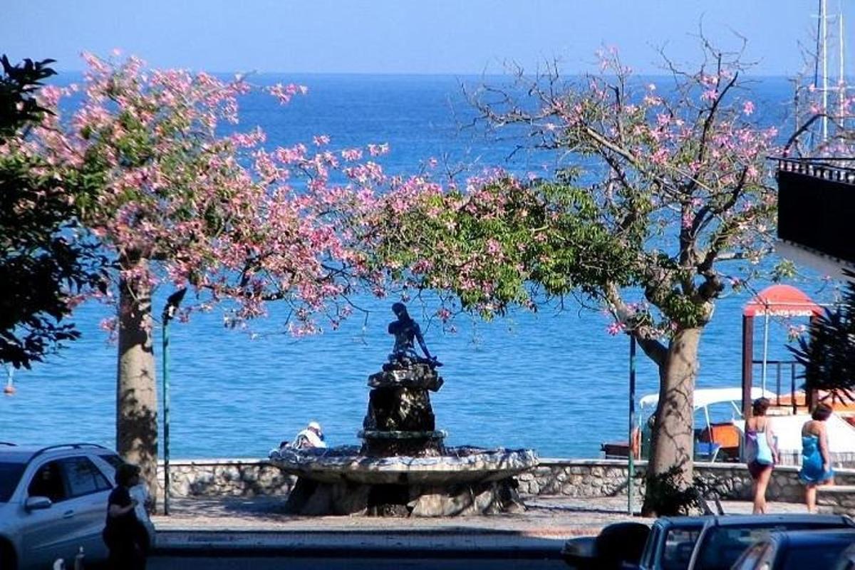 ένα σιντριβάνι με ένα άγαλμα μπροστά στο νερό