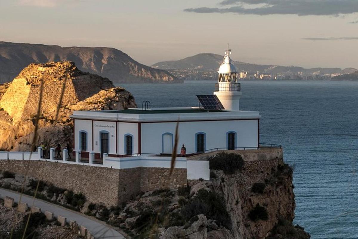 a lighthouse on a cliff next to the water