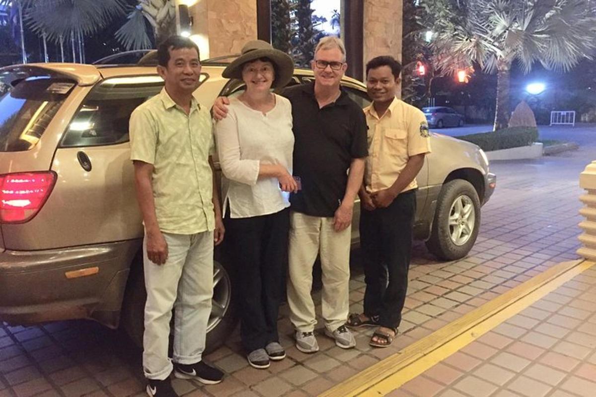 a group of people standing in front of a car